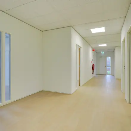 Bright hallway in an office space to rent at Regulierenring 2, Bunnik, with light wood flooring and white walls.