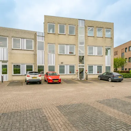 Exterior view of office building at Regulierenring 2, Bunnik, with parked cars and available office space to rent.