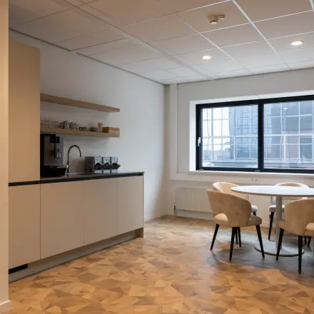 Furnished office space at Essebaan 63, Capelle aan den IJssel, featuring a kitchen area with seating and natural light. Ideal for those seeking office space rental with practical amenities.