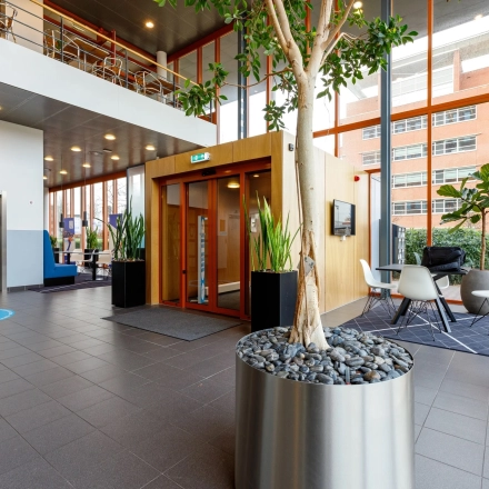 Modern office entrance at Fascinatio Boulevard 562, Capelle aan den IJssel, featuring sleek decor with seating area and plants, ideal for office space rental.