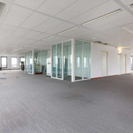 Spacious office interior at Fascinatio Boulevard 562, Capelle aan den IJssel featuring open floorplan and glass-enclosed conference rooms, ideal for office space rental.