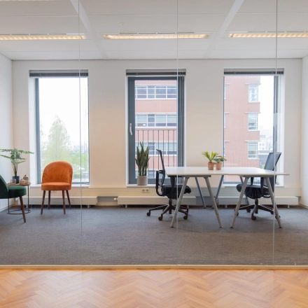 Furnished office space with desks, chairs, and plants at Fascinatio Boulevard 562 in Capelle aan den IJssel, available for rent. Large windows offer natural light.