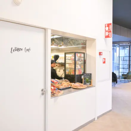 Entrance area at Rivium Quadrant 75, Capelle aan den IJssel featuring a café window with a selection of pastries, hinting at rentable office space options.