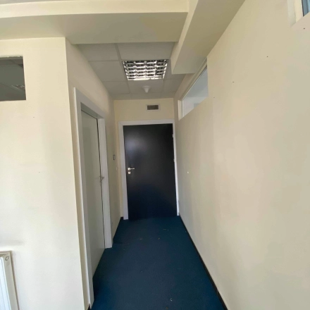 Hallway in an office space available for rent at Marcika 27, Cracow Łagiewniki Borek Fałęcki, featuring blue carpet and neutral walls.