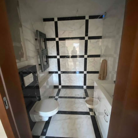 A restroom at Jastrzębia 24, Cracow Podgorze Duchackie, includes modern amenities with a stylish black and white tile design, ideal for an office space rental.