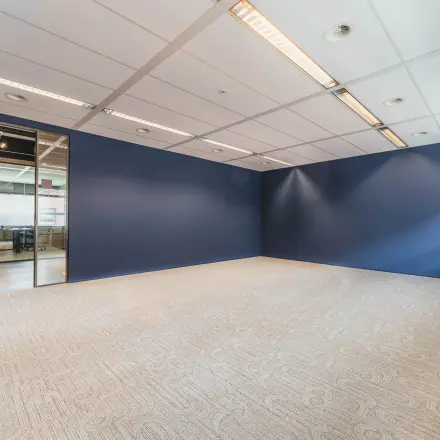 Spacious, unfurnished office space available for rent at Rijnzathe 12, De Meern, featuring a modern interior with blue walls and ample lighting.