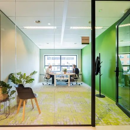 Modern office space for rent at Rijnzathe 12, De Meern, featuring a bright interior with two people collaborating at desks.