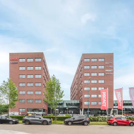 Exterior view of Rijnzathe 12 in De Meern featuring a modern office complex with multiple parked cars in the foreground.