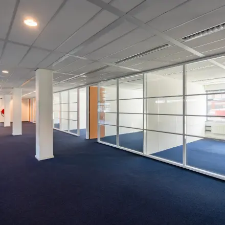 Spacious and bright office space for rent at Delftechpark 17-19 in Delft, featuring large windows and several partitioned areas ideal for office space rental.