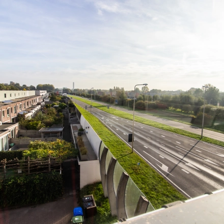 Exterior view of Marshalllaan 2 in Delft showing a peaceful roadside environment, ideal for those seeking office space rental with ease of access.