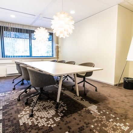Bright office space rental at Marshalllaan 2, Delft, featuring a modern conference room with stylish lighting and seating. Ideal for businesses seeking an office to rent.