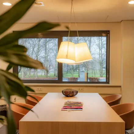 Office to rent at Marshalllaan 2, Delft, featuring a furnished interior with a large wooden table, comfortable chairs, and natural light from surrounding windows. Ideal for office space rental.