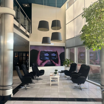 Modern lobby area with cozy black chairs, a small table, and large windows, perfect for office space rental at Olof Palmestraat 10, Delft.