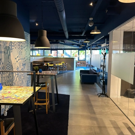 Office space at Amerikastraat 3 in Den Bosch featuring a modern interior with artistic decor and several workspaces. Ideal for office space rental with natural light and stylish furnishings.