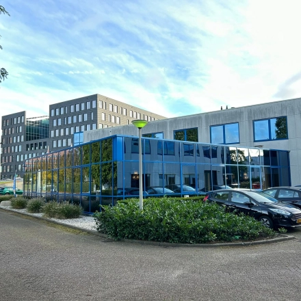 Exterior view of an office building at Amerikastraat 3, Den Bosch, showcasing modern architecture with reflective glass facade, perfect for office space rental.