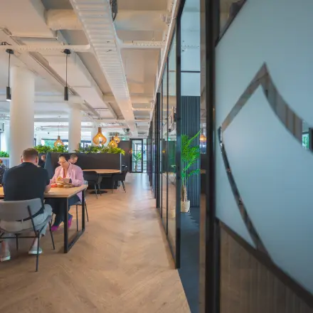 Business professionals collaborating in a modern, furnished workspace at Hambakenwetering 1, Den Bosch, ideal for office space rental.