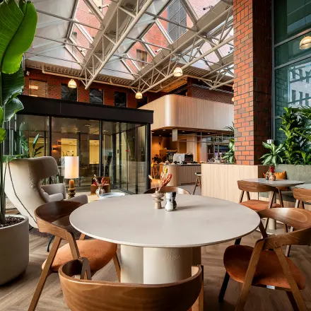 Inviting office space rental with stylish furniture at Hambakenwetering 5, Den Bosch, featuring modern seating and lush plants, ideal for collaborative work.