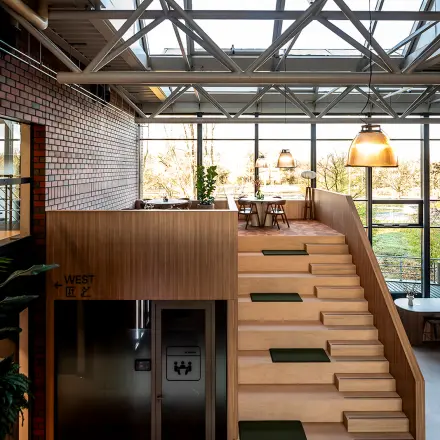 Modern, airy office at Hambakenwetering 5, Den Bosch with wooden staircase and large windows. Ideal for office space rental.