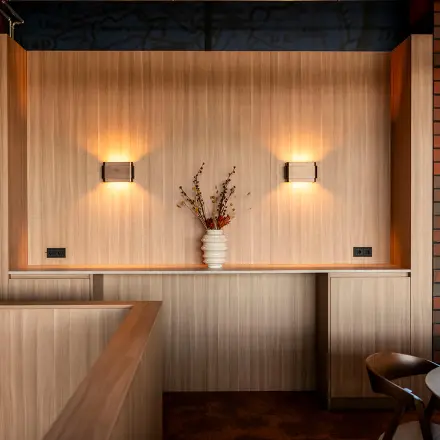 Cozy furnished office space at Hambakenwetering 5 in Den Bosch, featuring warm lighting and a decorative vase on a wooden counter, perfect for office space rental.