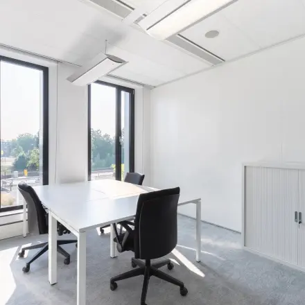 Bright office space at Willemsplein 2, Den Bosch, featuring minimalist furniture and large windows with city views, ideal for office space rental.