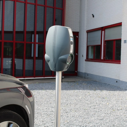 Exterior view of office space for rent at Keulenstraat 1, Deventer, featuring a parking area with an electric vehicle charging station.
