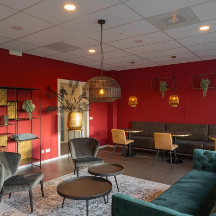 Furnished office space for rent at Keulenstraat 1, Deventer, featuring stylish seating areas with modern decor and ambient lighting.