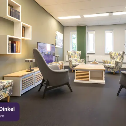 Cozy furnished office space at Keulenstraat 12, Deventer, suitable for rent with comfortable seating and shelving.