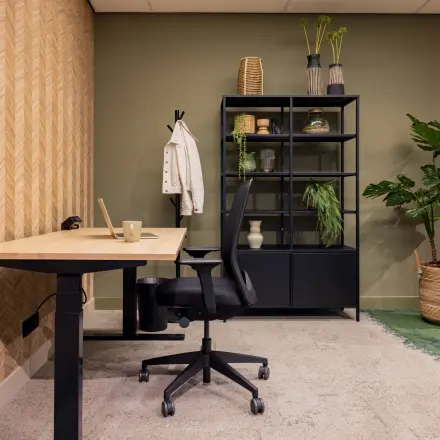 Modern office space for rent at Diemerhof 42, Diemen. Furnished with a desk, chair, and shelving unit, ideal for a productive work environment.