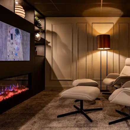 Cozy office space rental at Diemerhof 42, Diemen, featuring stylish chairs and a mounted TV with ambient lighting.