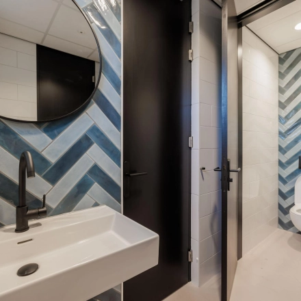 Modern restroom with blue and white tile design at an office space rental, Wisselwerking 40-48, Diemen.