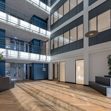 Spacious and modern office lobby with natural light streaming through large windows at Wisselwerking 40-48, Diemen. Ideal for office space rental with sleek design.