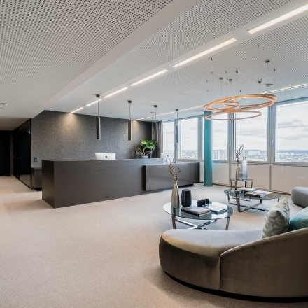 Spacious, elegantly furnished office with a sleek reception desk and comfortable seating area, ideal for office space rental in Düsseldorf Old Town's Dreischeibenhaus 1.
