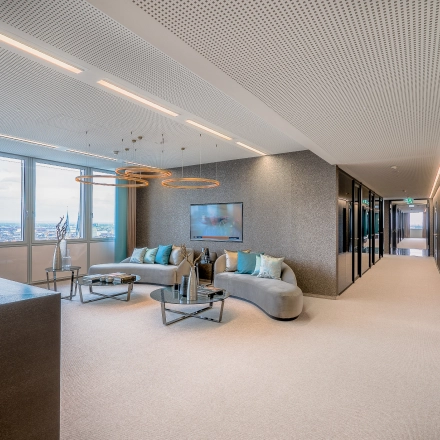 Bright, furnished office space with a seating area and large windows offering city views in Düsseldorf Old Town, perfect for office space rental.