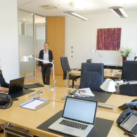 Modern office space at Königsallee 14, Düsseldorf Old Town with professionals working on laptops. Suitable for office space rental.