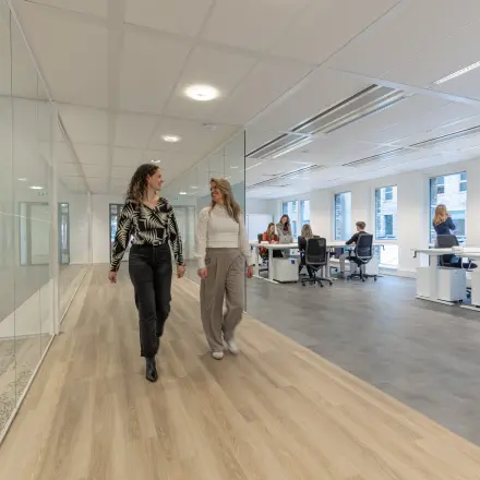Modern office space rental at Flight Forum 120-159, featuring bright workspaces with large windows and people collaborating at desks.