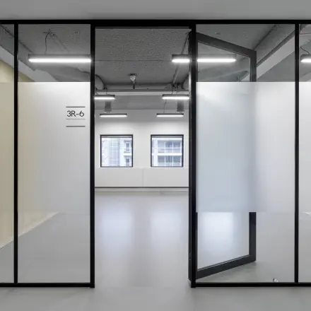 A modern office space rental in Eindhoven Center with frosted glass partitions and large windows offering natural light, suitable for businesses looking to rent office space.