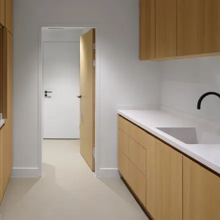 Modern office space rental at Paradijslaan 30-38, Eindhoven Center, featuring a sleek, minimalistic kitchen area with wooden cabinetry and a streamlined design.
