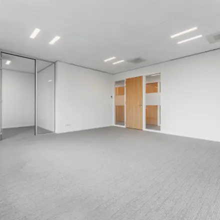 Spacious office to rent at Hurksestraat 60, featuring large windows and modern lighting in Eindhoven's De Hurk district.
