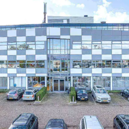 Exterior view of a modern office building at Meerenakkerplein 1-10, Eindhoven De Hurk, with parking spaces available for office space rental.