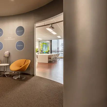 Modern office interior at Meerenakkerplein 11-20, Eindhoven De Hurk with stylish seating and visible meeting room, ideal for rent office space.