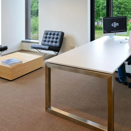 Modern office space at High Tech Campus 10, Eindhoven featuring sleek furniture with a professional working at a desk, ideal for office space rental.
