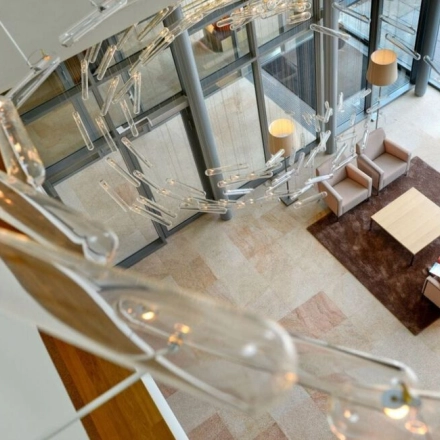 Spacious office lounge with modern seating arrangement and stylish lighting at High Tech Campus 10, Eindhoven. Ideal for informal meetings and relaxation, this space enhances your office space rental experience.