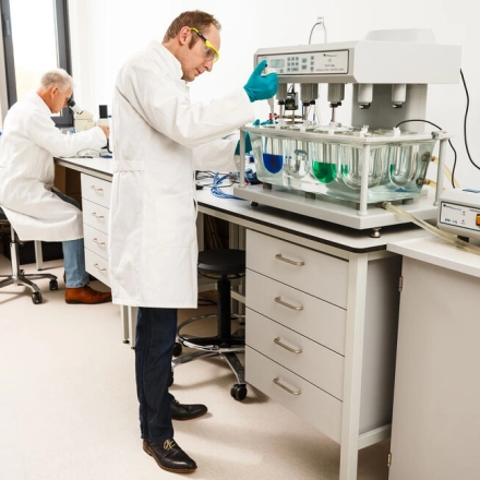 Two people in lab coats are working with scientific equipment in a clean laboratory space at High Tech Campus 10, Eindhoven. A bright and professional environment suitable for research and development activities.