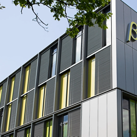 Modern exterior view of High Tech Campus 9, Eindhoven, featuring sleek designs and vibrant yellow accents. Ideal for office space rental in a prime technology hub.
