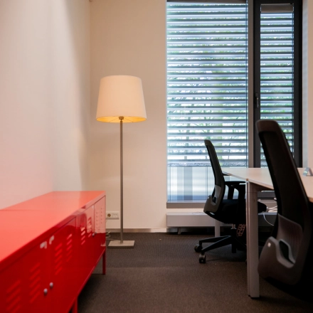 Bright office space at High Tech Campus 9, Eindhoven, featuring modern desks, ergonomic chairs, and a stylish floor lamp, ideal for productive workdays.