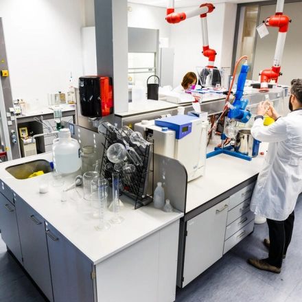 Scientists in lab coats conducting experiments in a modern laboratory at TU campus, De Lismortel 31, Eindhoven High Tech Campus. This office space rental offers advanced facilities for research and development.