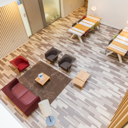 Bright office space for rent at TU Eindhoven High Tech Campus. Features modern furnishings with seating and tables, ideal for workspace or office space rental.
