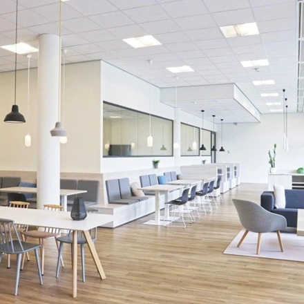 Bright office space with modern furniture, featuring several tables and chairs arranged for collaborative work at Anderlechtstraat 15 in Eindhoven North. Ideal for office space rental.