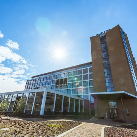 Exterior view of the office building at Achtseweg Zuid 159R, Eindhoven Strijp-S, showcasing a modern structure with clear skies, ideal for office space rental.