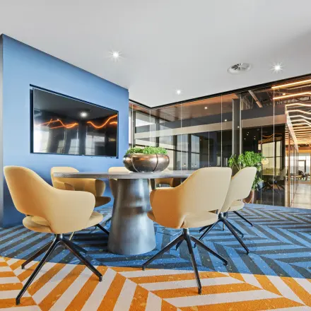 A modern meeting room with a sleek table, chairs, and a large TV in an office to rent at Achtseweg Zuid 159R, Eindhoven Strijp-S.